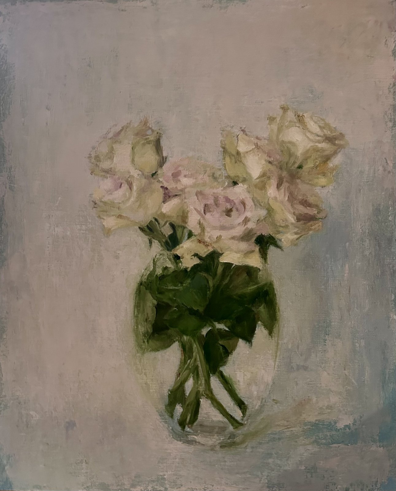 Pale roses in a glass vase against a soft grey background