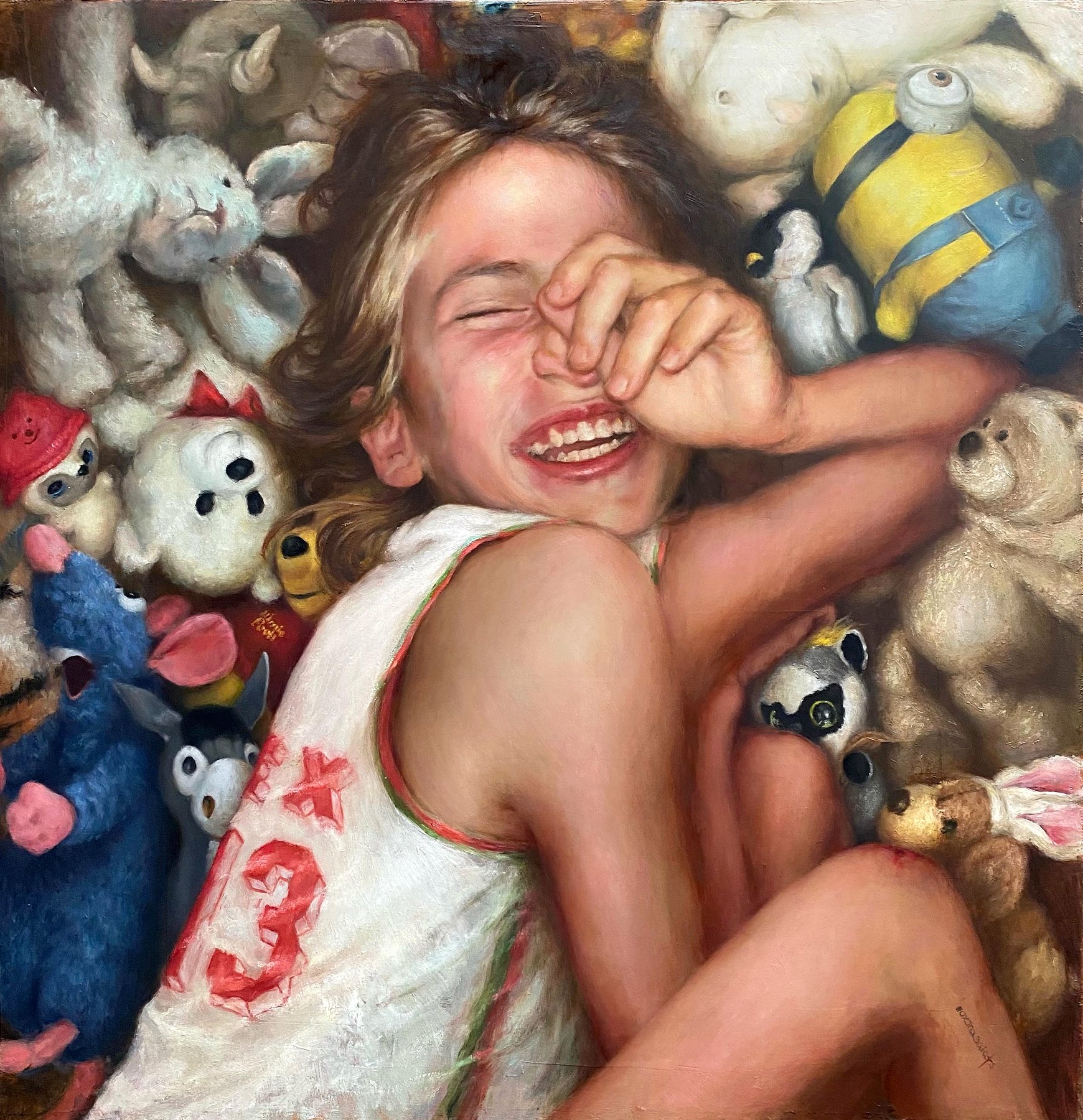 A laughing child smiling among stuffed animals