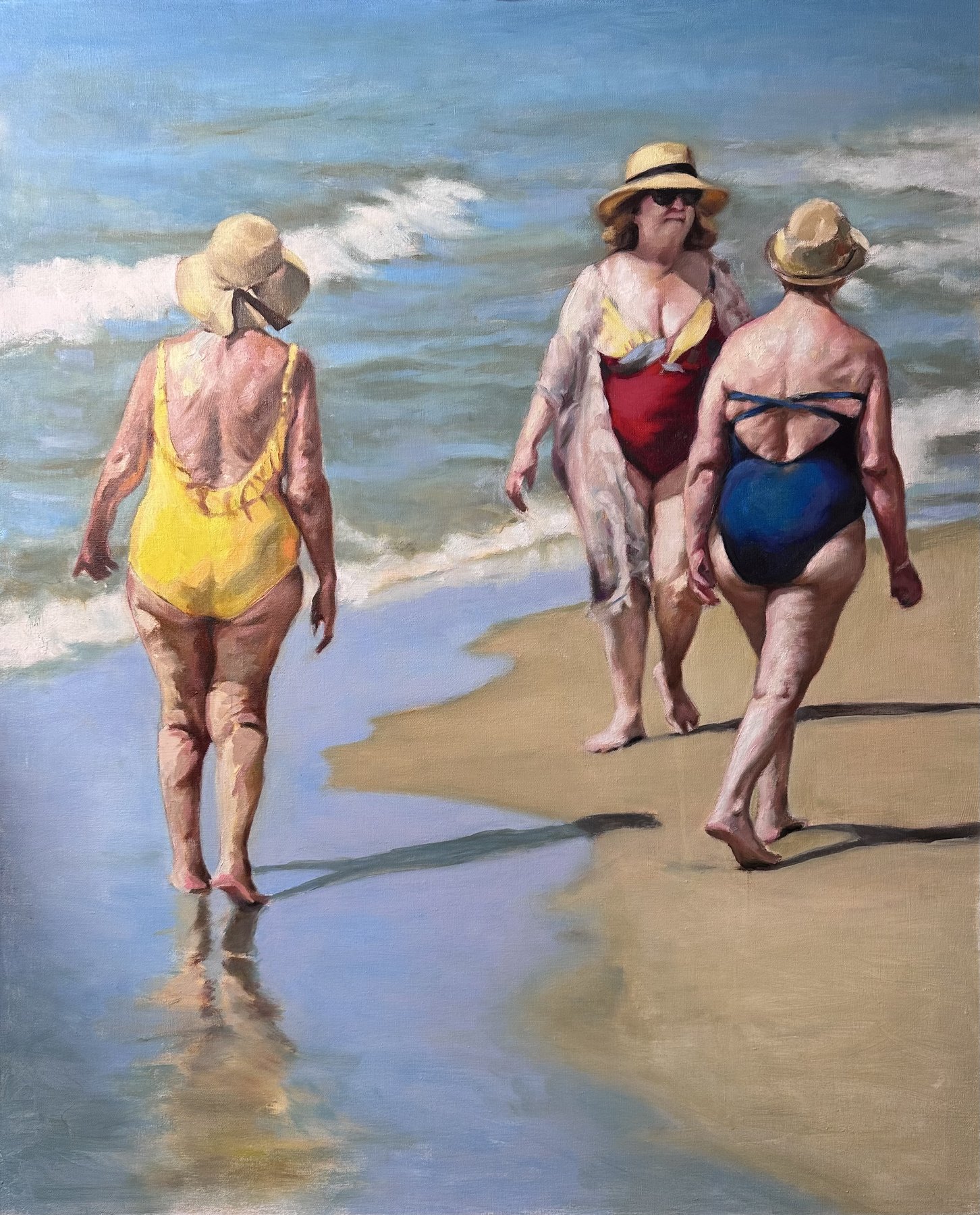 Three women in swimsuits and sun hats walking away along the shoreline